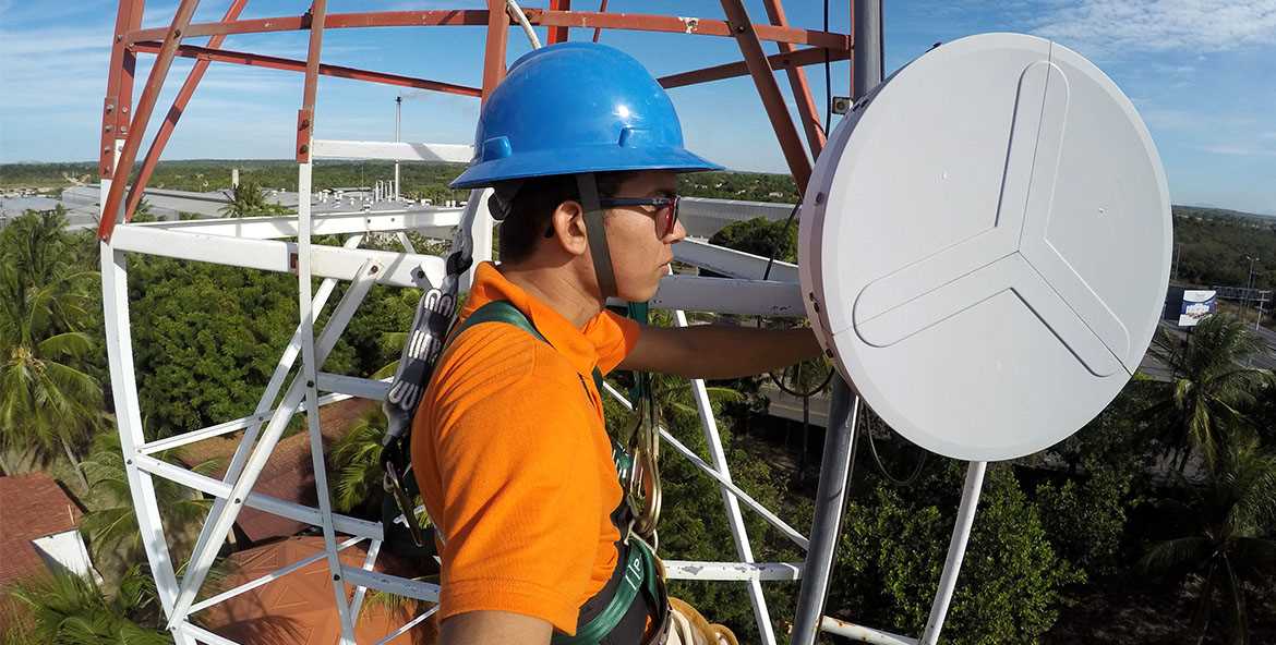 Técnico no topo de uma torre de internet