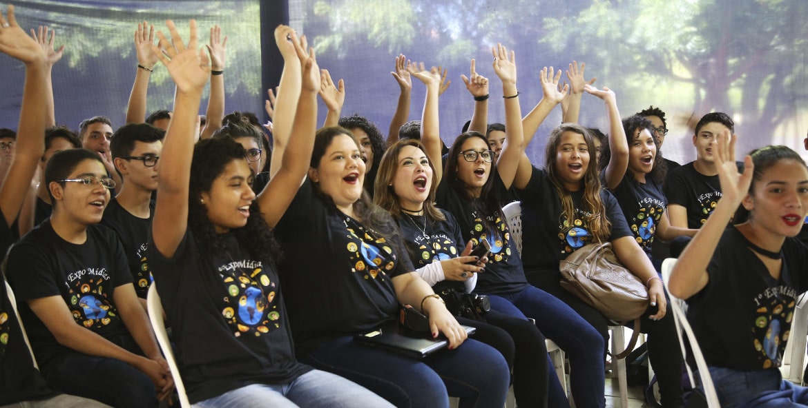 Grupo de alunos levantando as mâos e gritando